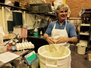 Richard Bourdon stands in front of a tub of dough
